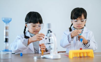 Two girls doing science experiments in a lab. Two girls doing science experiments in a lab. Selective focus.